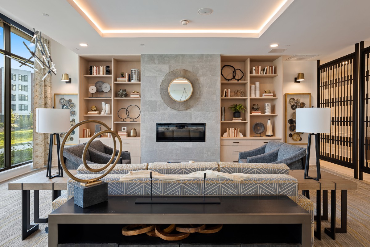 A modern living room with stylish decor, featuring a central fireplace and built-in shelves.