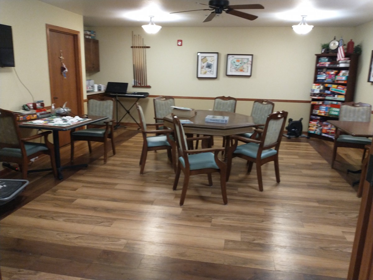A cozy dining area with a round table, chairs, and wooden flooring.