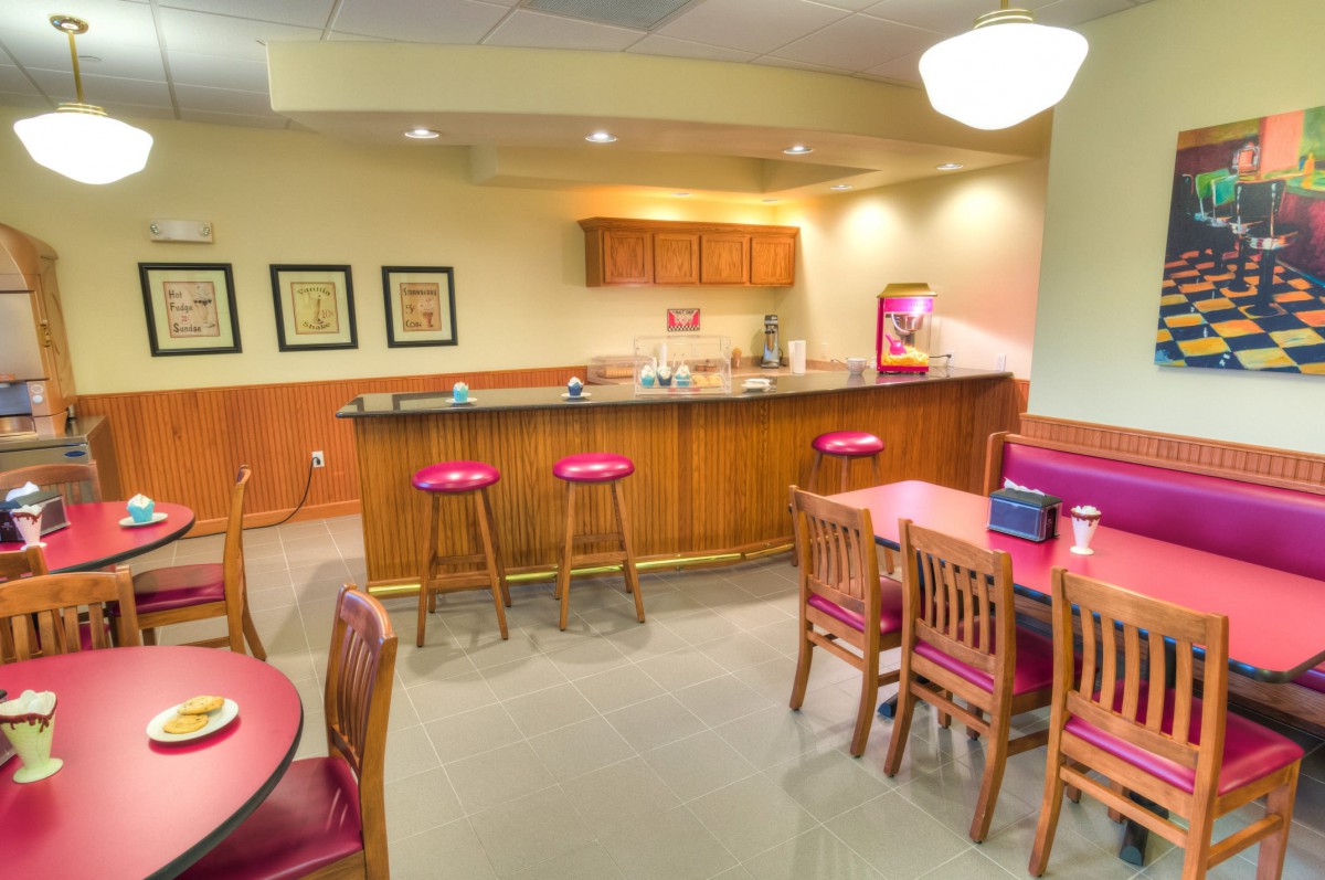 A cozy kitchen and bar area with stools and tables, ideal for casual dining.