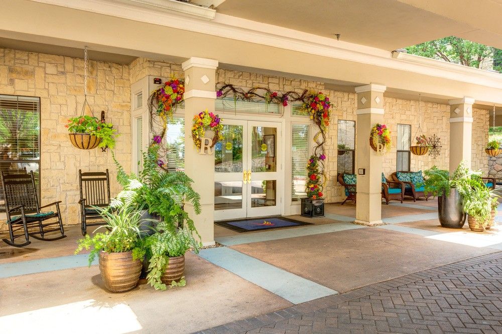 A decorated building entrance with potted plants and seasonal decorations.