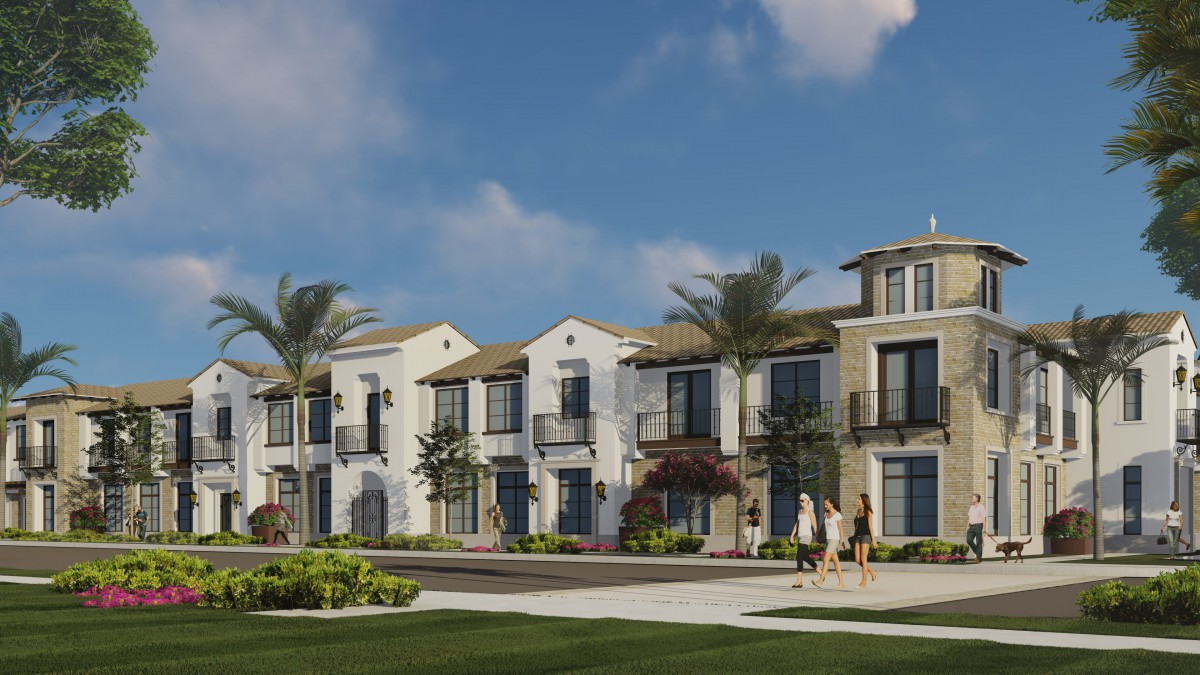 Modern residential housing development with palm trees and a clear blue sky.