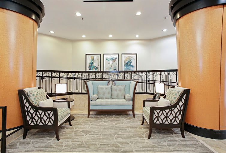 A modern lounge seating area with elegant furniture and decorative artwork.