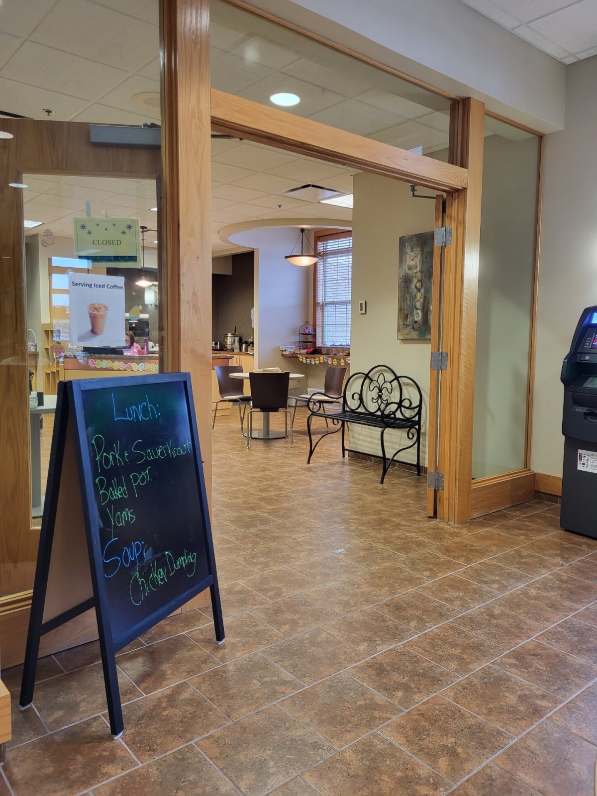 A cozy cafe entrance with a menu board and seating area.