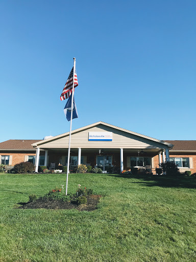 A community building with flags standing proudly against a clear blue sky.