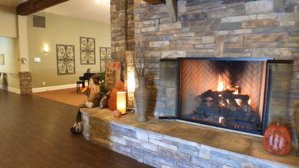 A cozy living room with a stone fireplace and warm lighting creates a welcoming atmosphere.