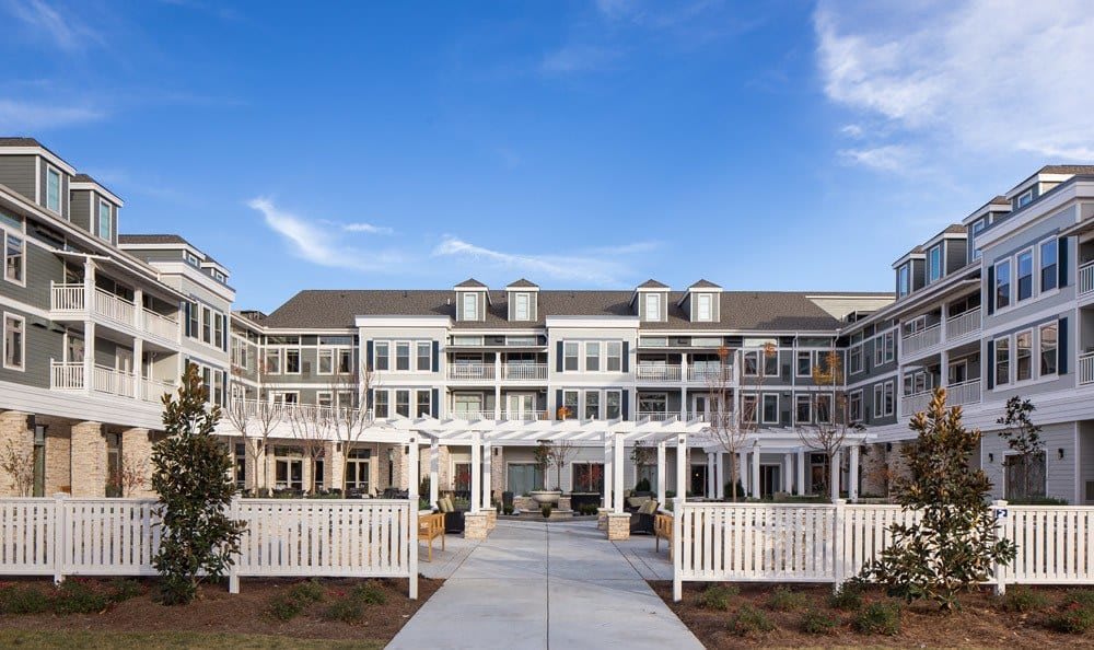 A modern residential building with a bright facade and clear blue sky.