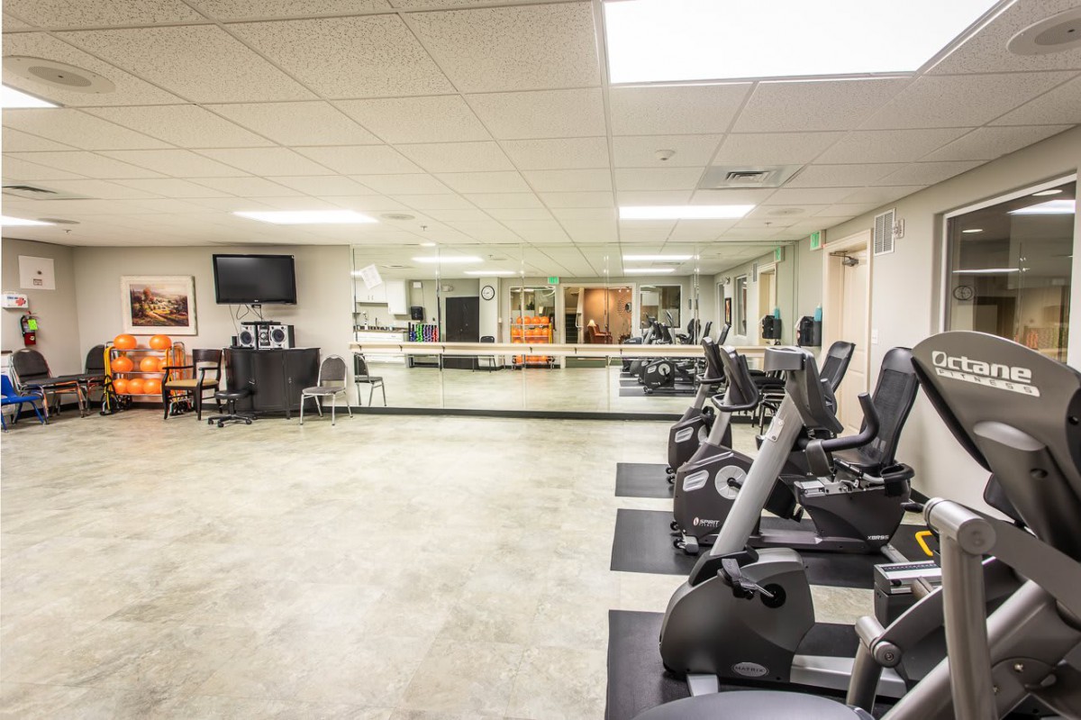 A spacious fitness center with exercise equipment and large mirrors.
