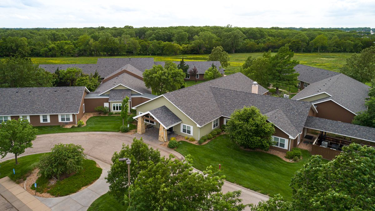 Aerial view of suburban houses surrounded by lush greenery.