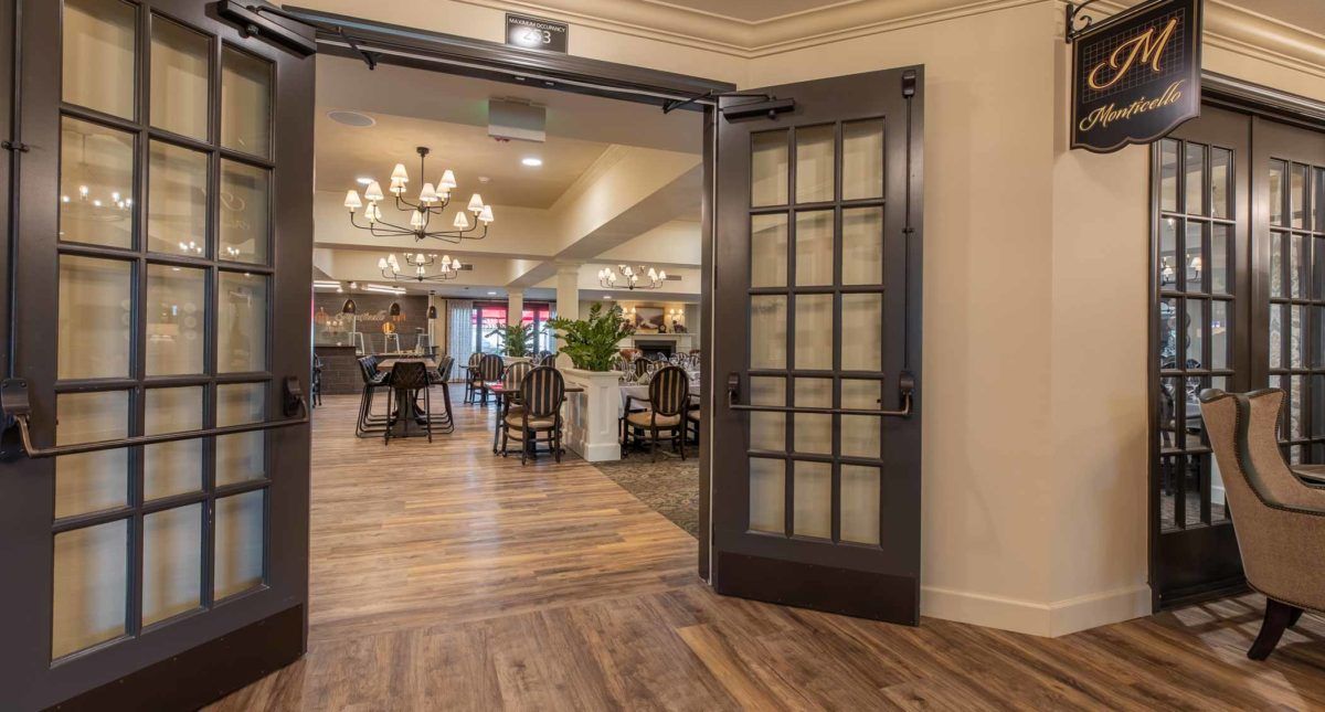 An inviting dining area with elegant chandeliers and wooden flooring.