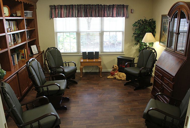 A cozy waiting room with several chairs arranged in a circle near a window.