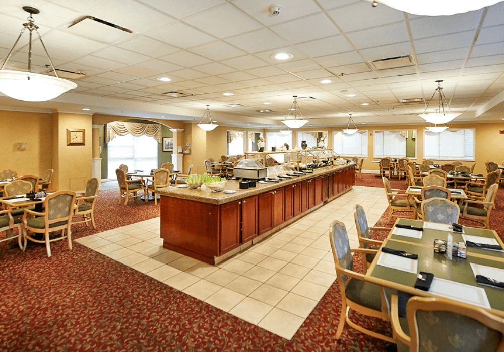 An elegantly designed dining area with a central buffet setup, featuring comfortable seating and ambient lighting.
