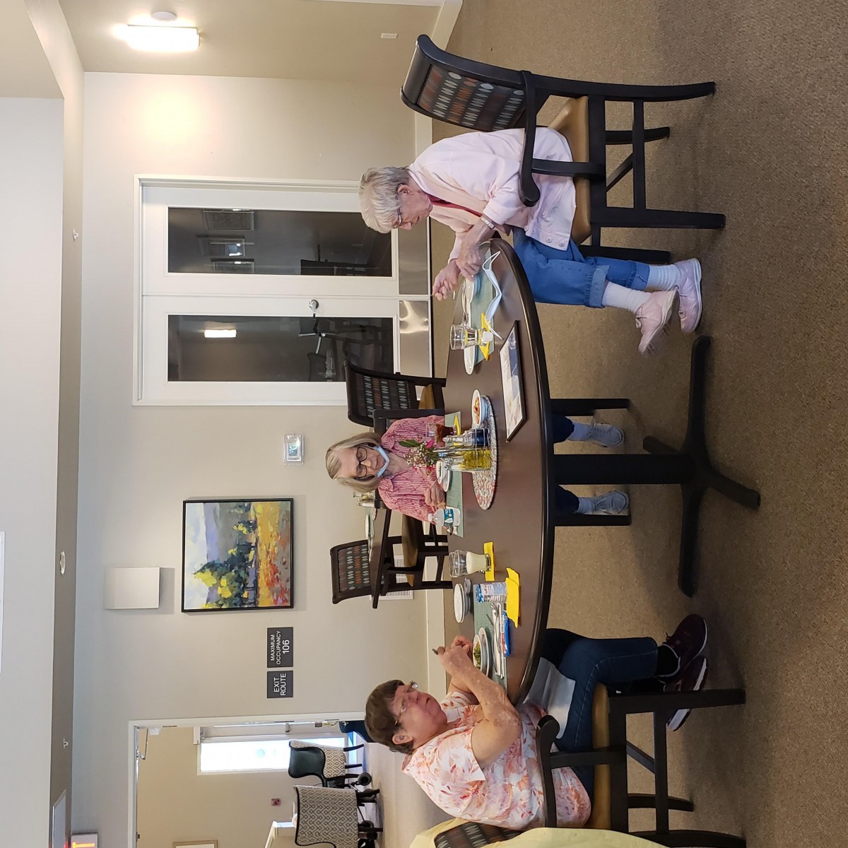 A group of seniors engaged in crafting activities around a table.
