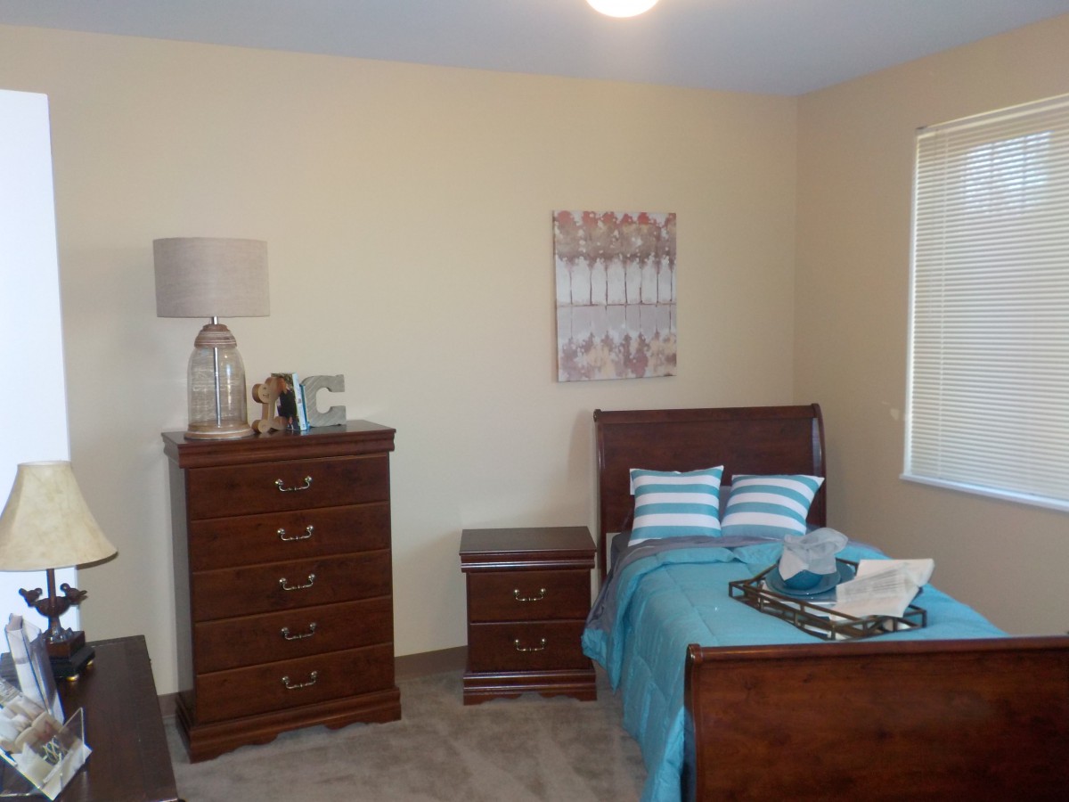 A cozy bedroom with wooden furniture and teal accents.