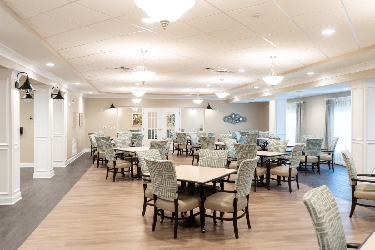 A spacious and well-lit dining area with multiple tables and chairs arranged neatly.