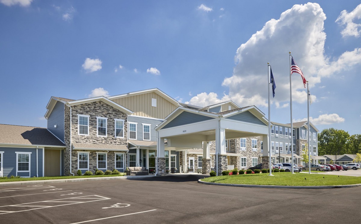 Exterior view of a large hotel building under a blue sky with scattered clouds.