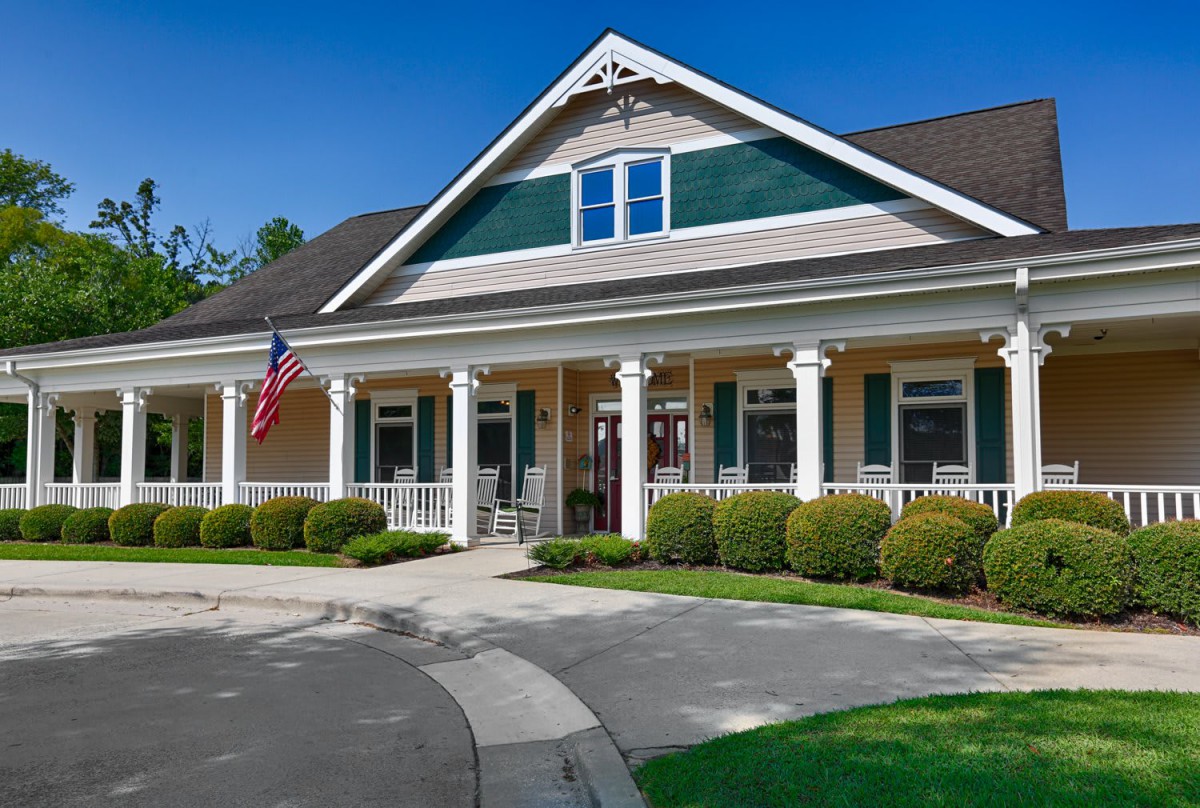 A beautiful single-story house with white columns and a manicured garden.