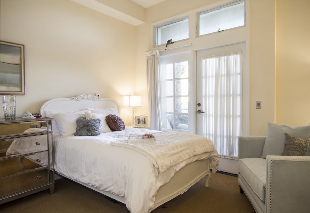 A cozy bedroom with a comfortable bed and ample natural light.