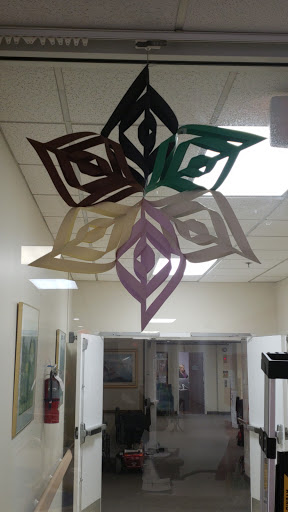 Colorful paper snowflakes suspended in an interior space.