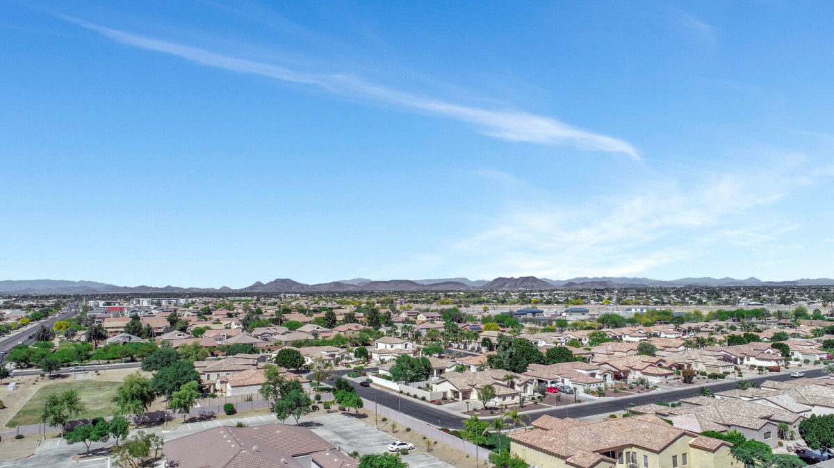 Aerial view of a suburban residential area with houses and clear skies.