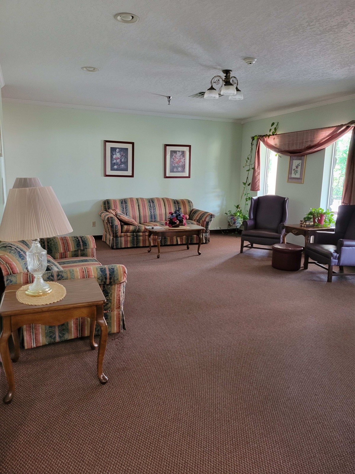 A cozy living room with sofas, armchairs, and decorative elements.