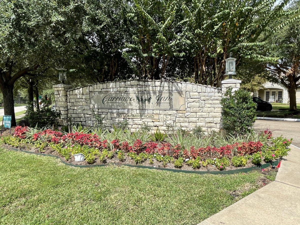 A beautifully landscaped garden featuring vibrant flowers and a stone wall.