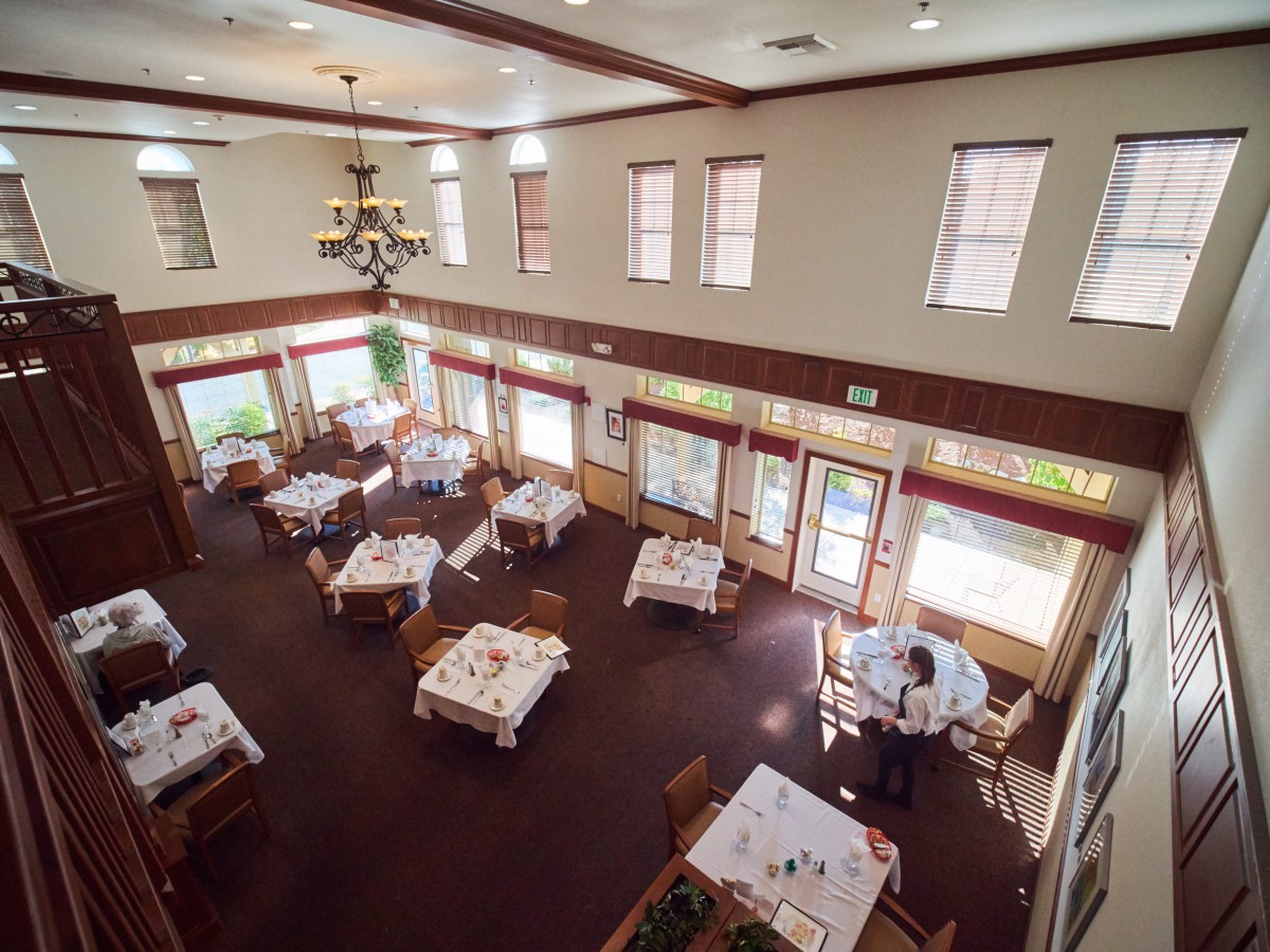 An elegant restaurant dining area with neatly arranged tables and a chandelier.