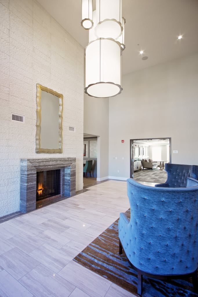 A modern living room featuring a cozy fireplace and stylish blue seating.