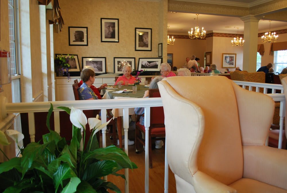 Seniors relaxing in a cozy retirement home interior with photographs on the walls.