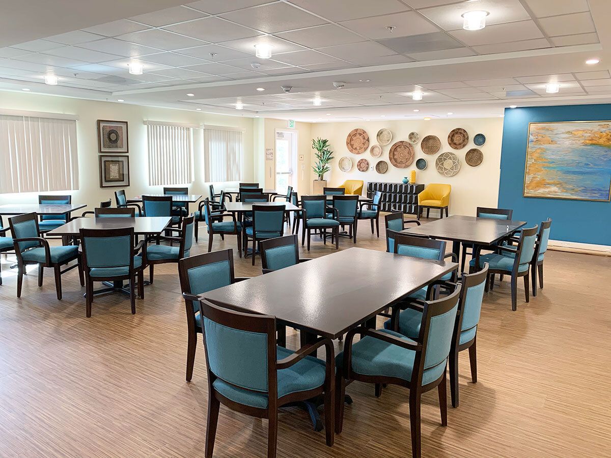 A modern dining area featuring several tables and chairs, with art adorning the walls.
