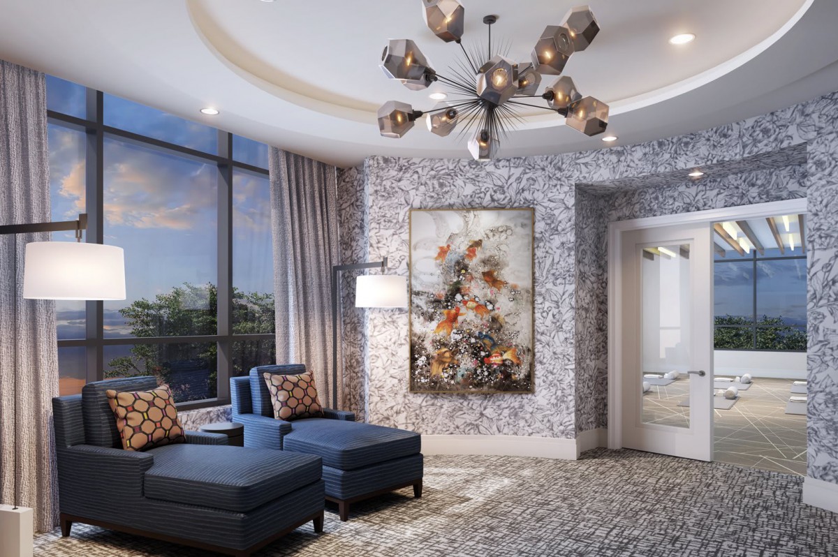A modern living room featuring a stylish chandelier, luxurious blue seating, and a large piece of floral artwork under natural light from expansive windows.