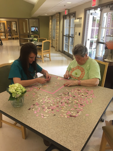 Two individuals engaged in assembling a puzzle together, enjoying a moment of creativity.