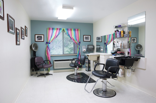A cozy and colorful hair salon interior with stylish chairs and vibrant curtains.