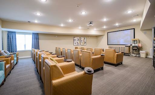 A modern conference room designed for comfort and productivity, featuring plush seating and a large projector screen.