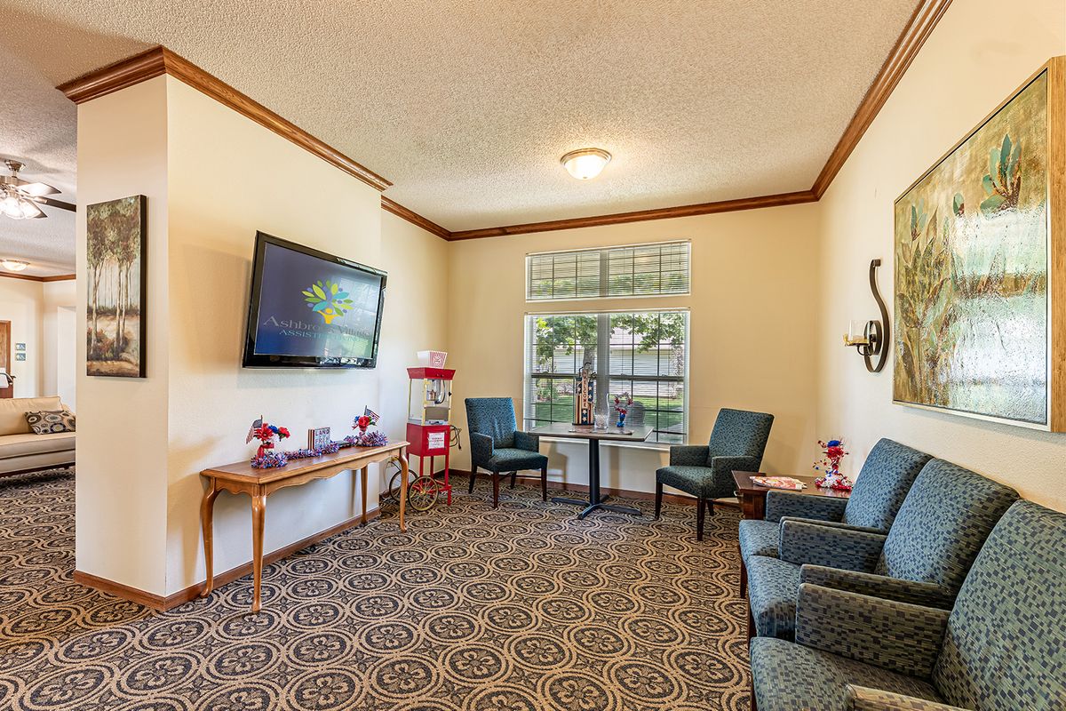 A cozy living room with comfortable seating, a wall-mounted television, and decorative elements.