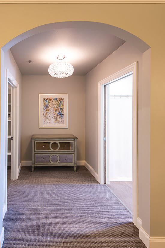 A bright hallway with a console table and artwork on the wall.