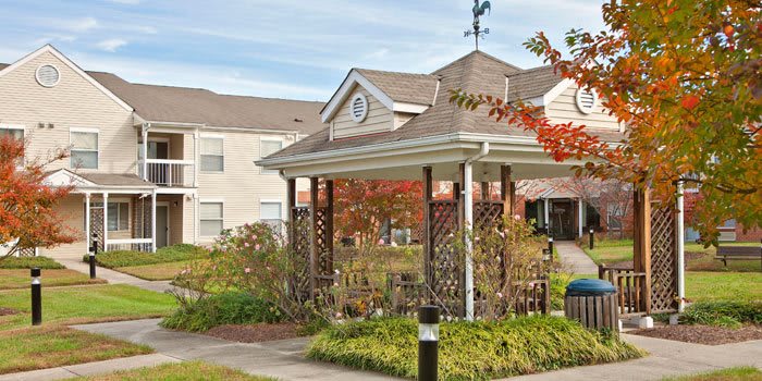 A charming gazebo in a suburban garden setting during autumn.