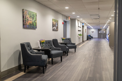 A well-lit and elegantly designed waiting area featuring comfortable seating and decorative art on the walls.