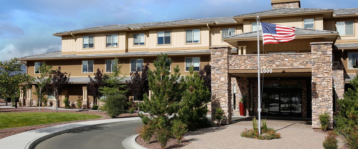 A modern hotel exterior with stone accents and landscaped surroundings.