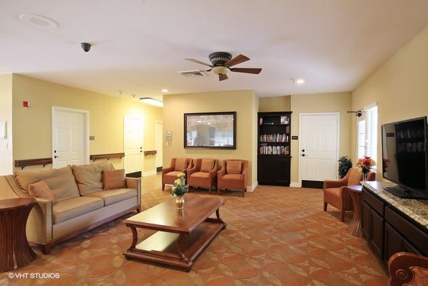 A cozy living room with comfortable seating and a ceiling fan.