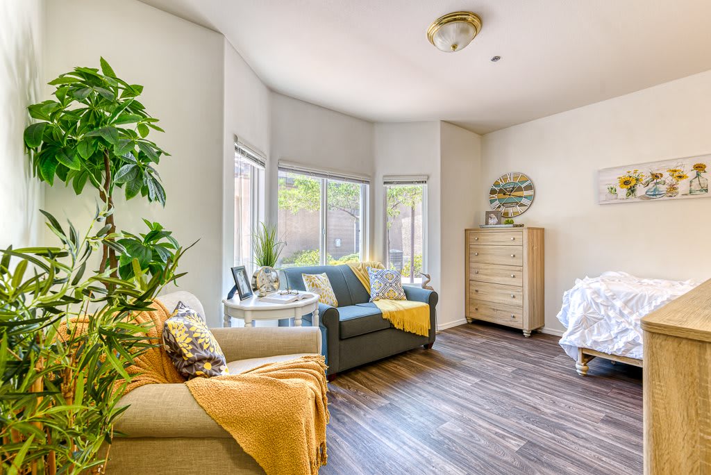 A cozy living room with modern decor, featuring a comfortable armchair, wooden flooring, and plenty of natural light.