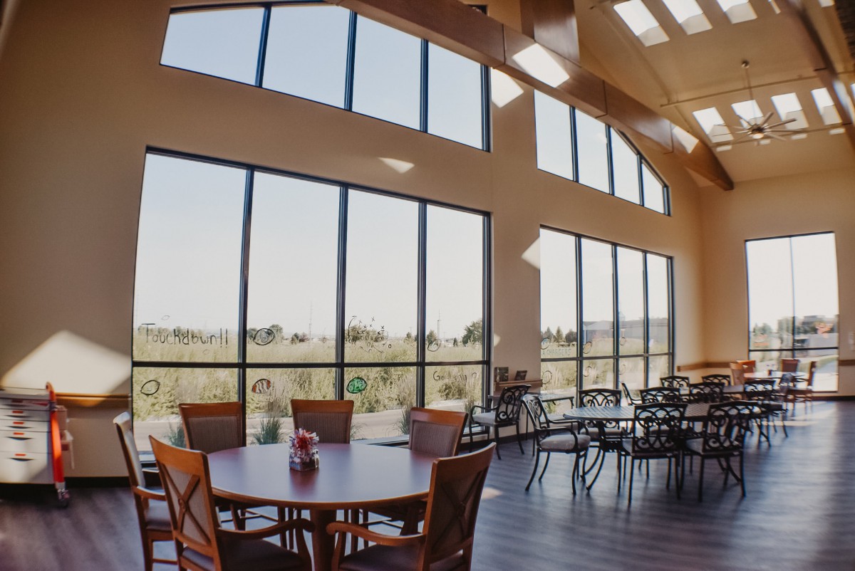 A bright and airy cafe interior with large windows overlooking a scenic landscape.