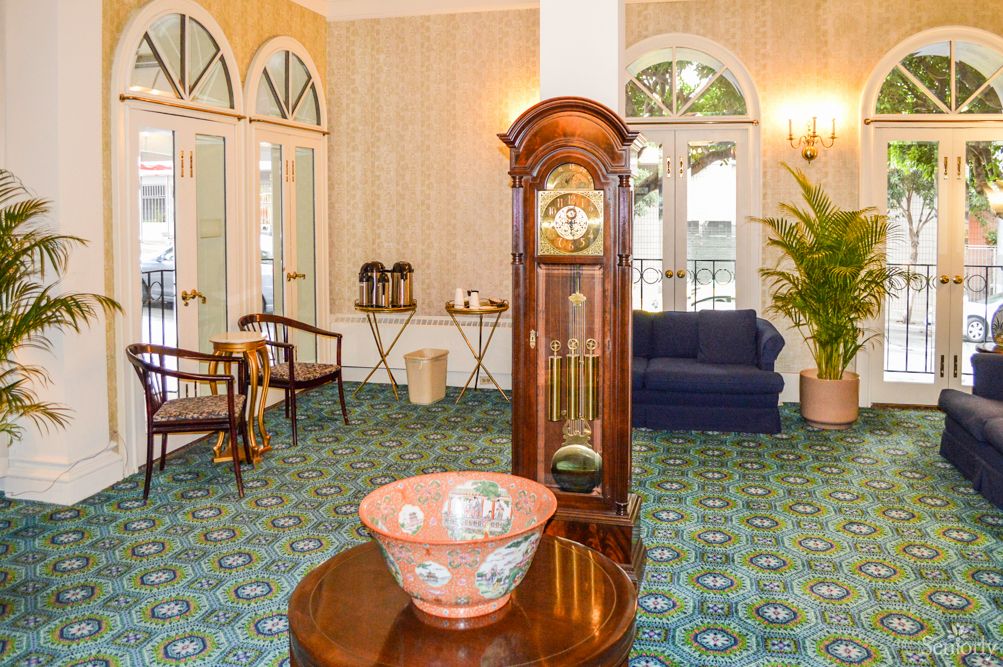 A stylish living room featuring a grandfather clock, elegant decor, and comfortable seating.