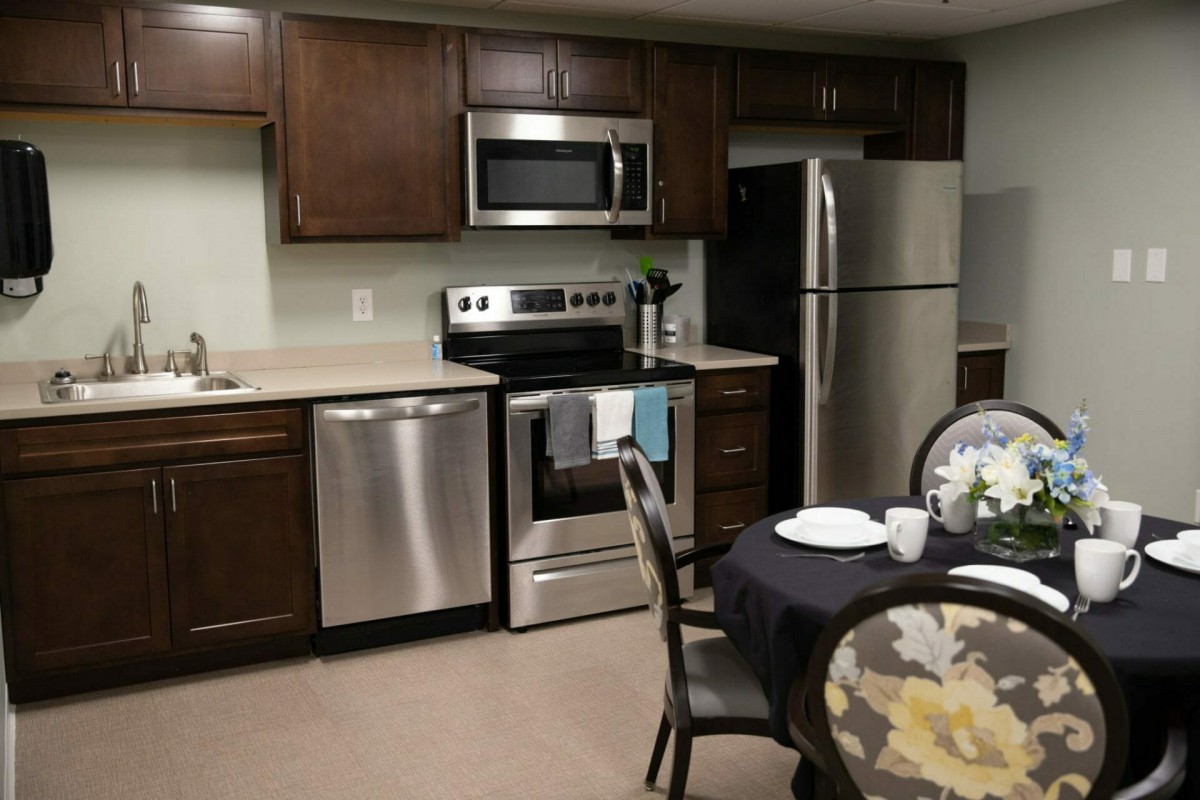 A modern kitchen with stainless steel appliances and a cozy dining area.