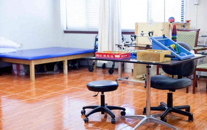 A rehabilitation room equipped with a therapy bed and medical equipment.