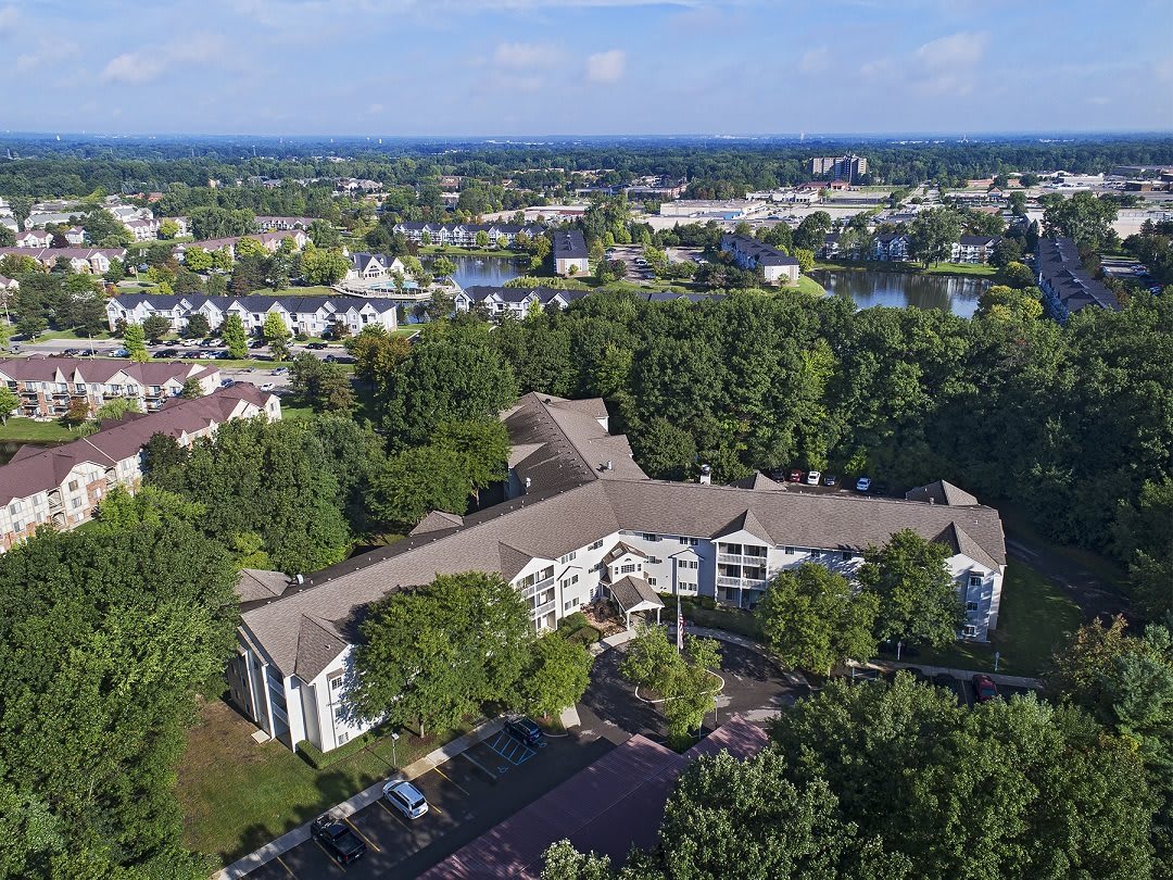 Aerial view of a suburban building surrounded by trees and greenery.