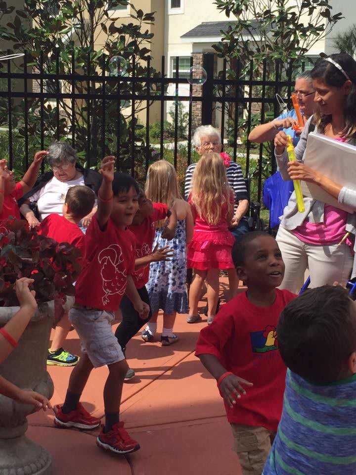 Children enjoying an outdoor group activity with a teacher or guide.