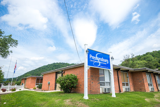 A view of a building with a prominent sign, set against a backdrop of clouds and rolling hills.