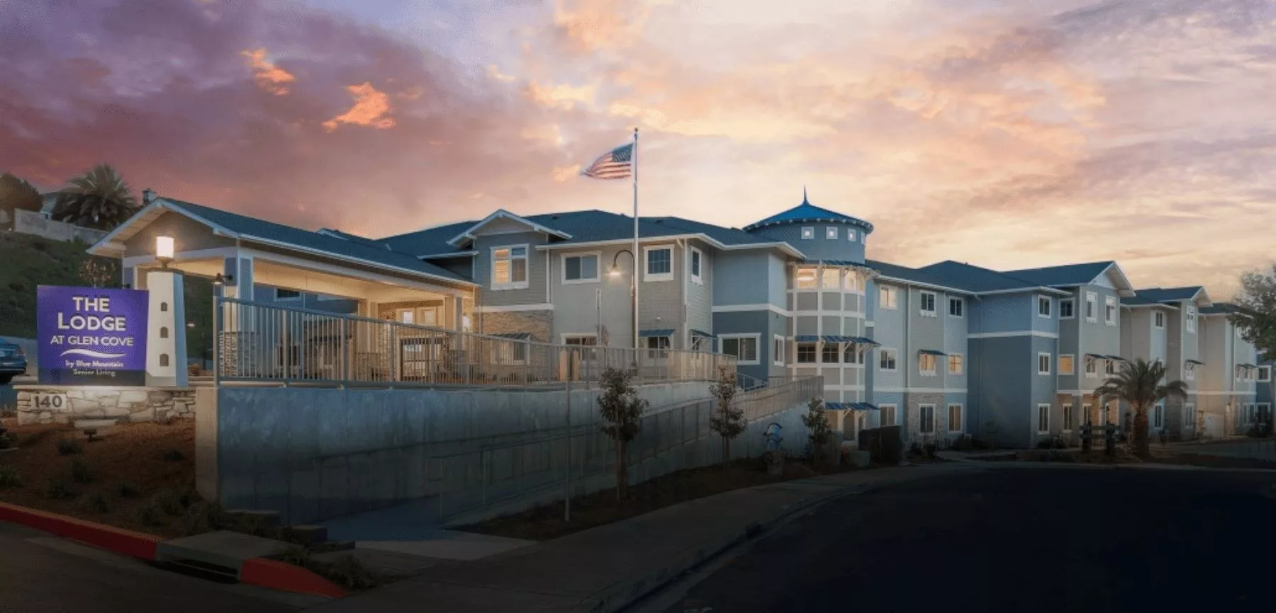 A beautiful residential building at sunset with a flag flying in front.
