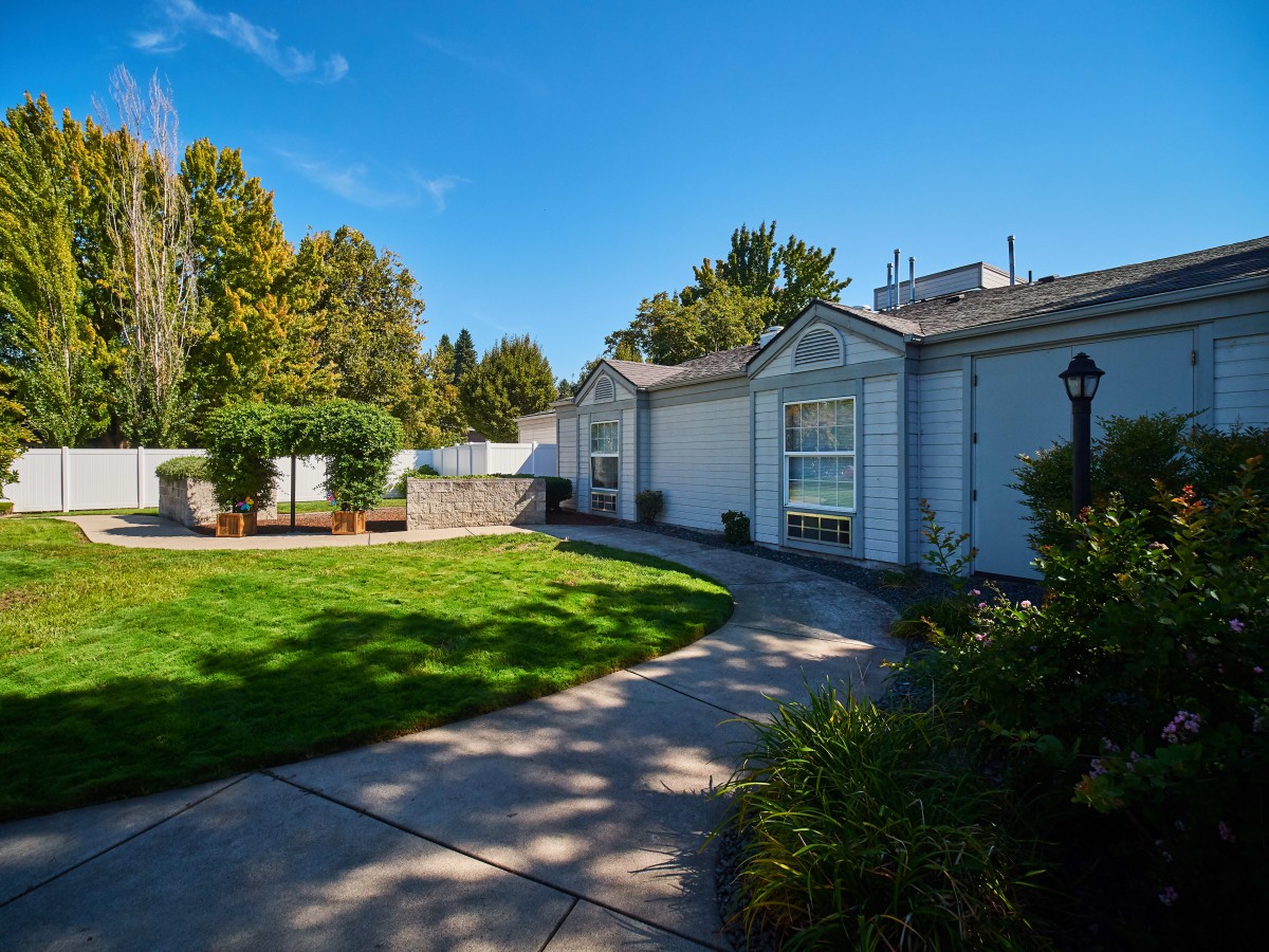A suburban house with a well-maintained lawn and garden on a sunny day.