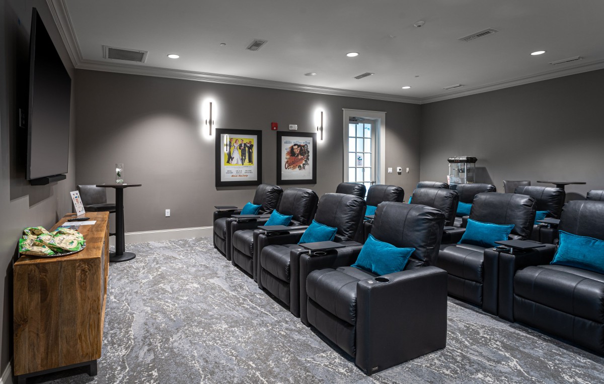 A cozy home theater room with reclining seats and decorative cushions.